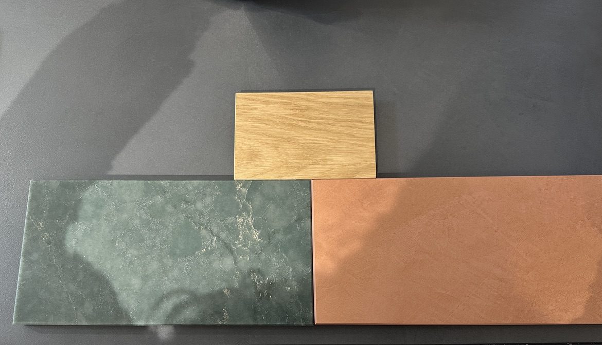 Material swatches - Silestone Jardín Emerald, Dekton Umber, and oak side by side