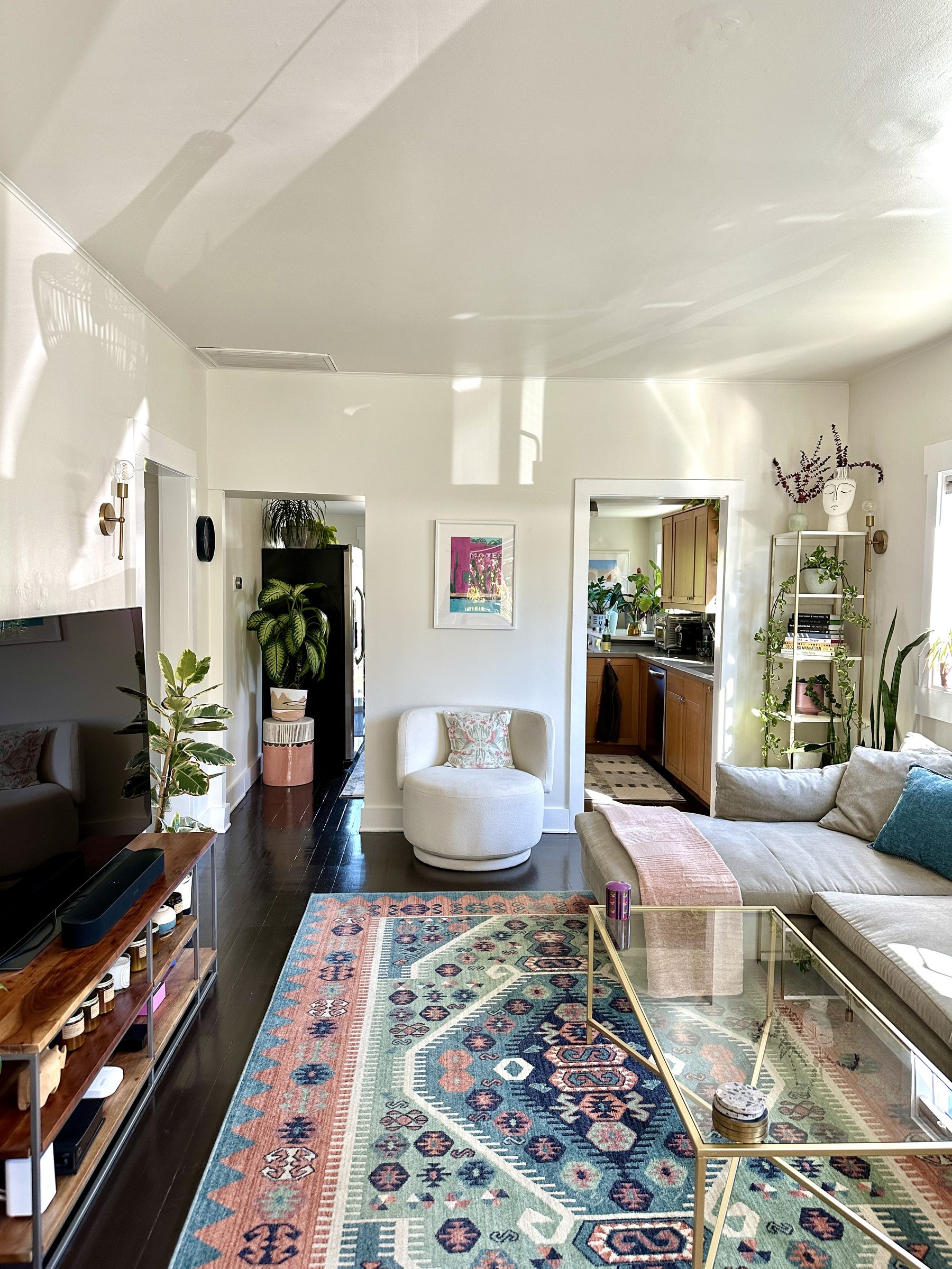 Original living room with dark floors and doorways to kitchen