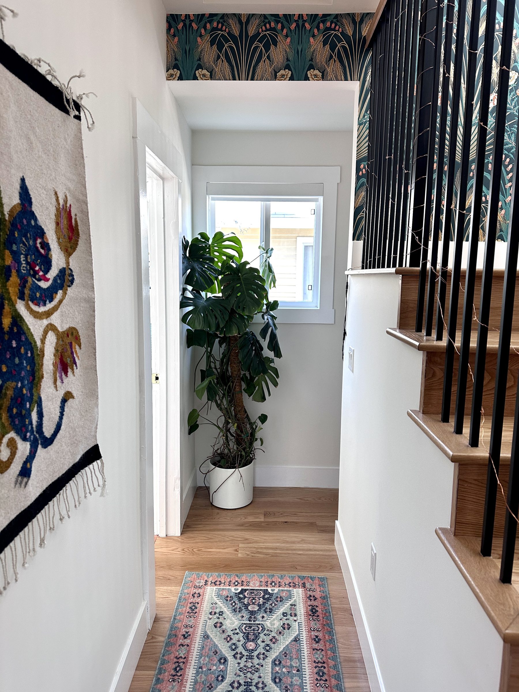 Renovated hallway with monstera and staircase