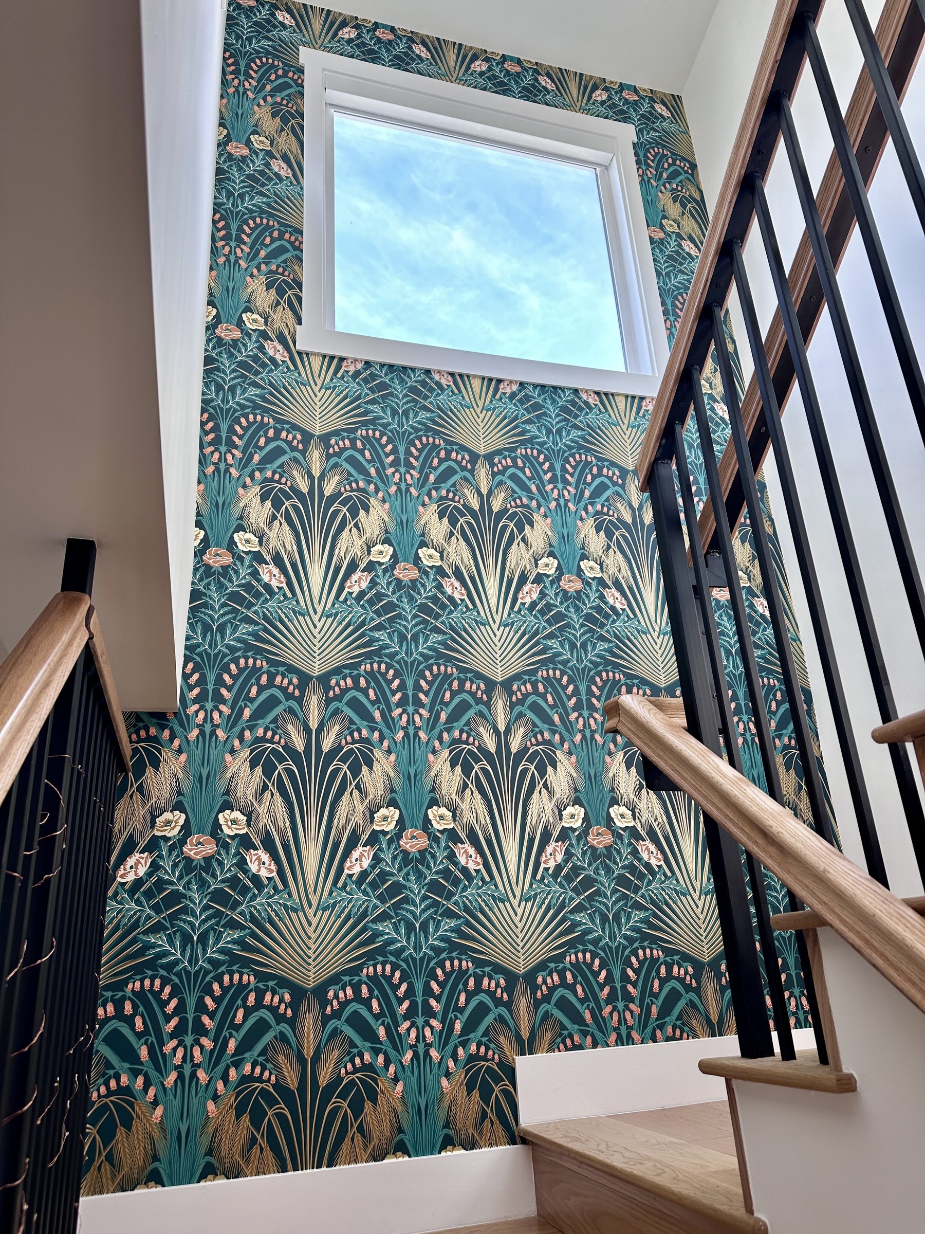 Wallpaper detail looking up the staircase with sky through window